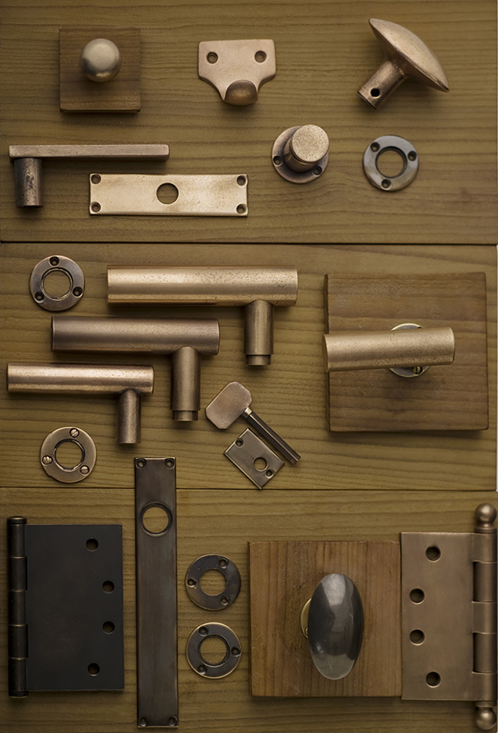 Collection of minimalist solid bronze hardware in a distressed custom finish.